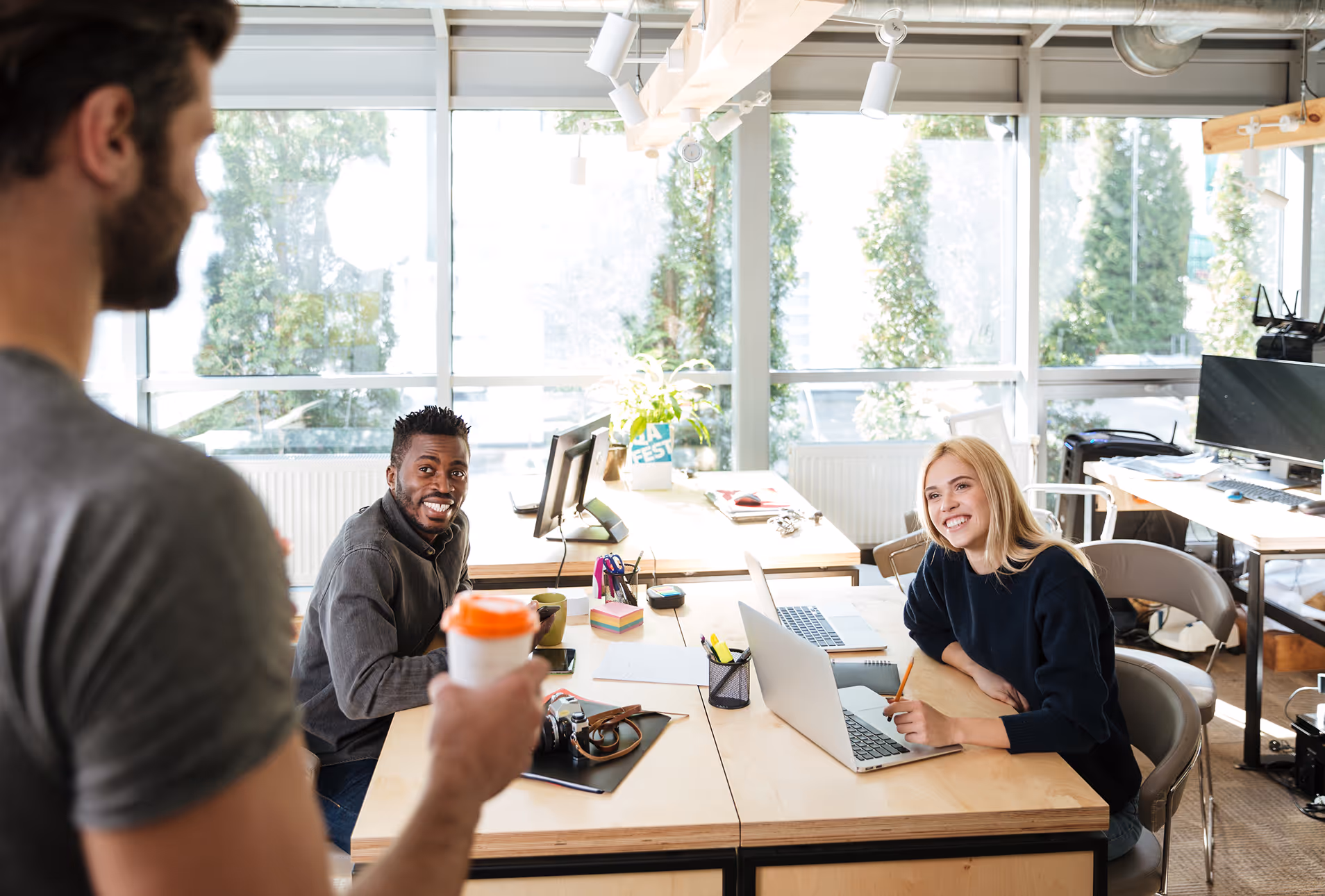 Trois collègues échangent dans un bureau lumineux du HUB612